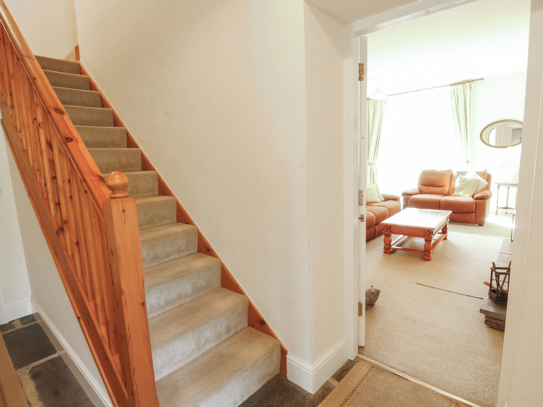 A staircase leading to a living area with a sofa and a coffee table.
