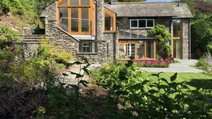 A stone house with large windows and a stone chimney. - Spring Cottage (Ambleside)