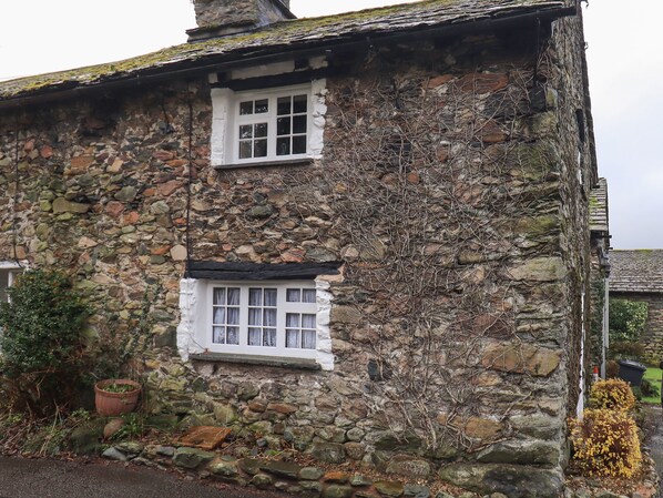 Ein Steinhaus mit kleinem Fenster und Schornstein.