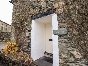 Ein Steinhaus mit einer weißen Tür und einem Schild mit der Aufschrift '2 How Head'.