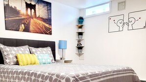 Une chambre à coucher moderne avec un grand lit, un tableau représentant un paysage urbain, une petite fenêtre et une étagère décorative agrémentée de plantes.