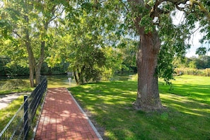 A paved pathway leading through a park with trees and a grassy area. - Schnack-Stuuv - Great 72sqm apartment for 4 people with terrace in the (Krummhörn)