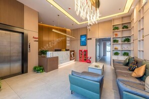 A modern hotel lobby with a reception desk, seating area, and a reception counter. - Taoyuan Hotel (Foshan Guanyao Branch) (Foshan)