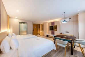 A hotel room with two beds, a dining table, and a TV.