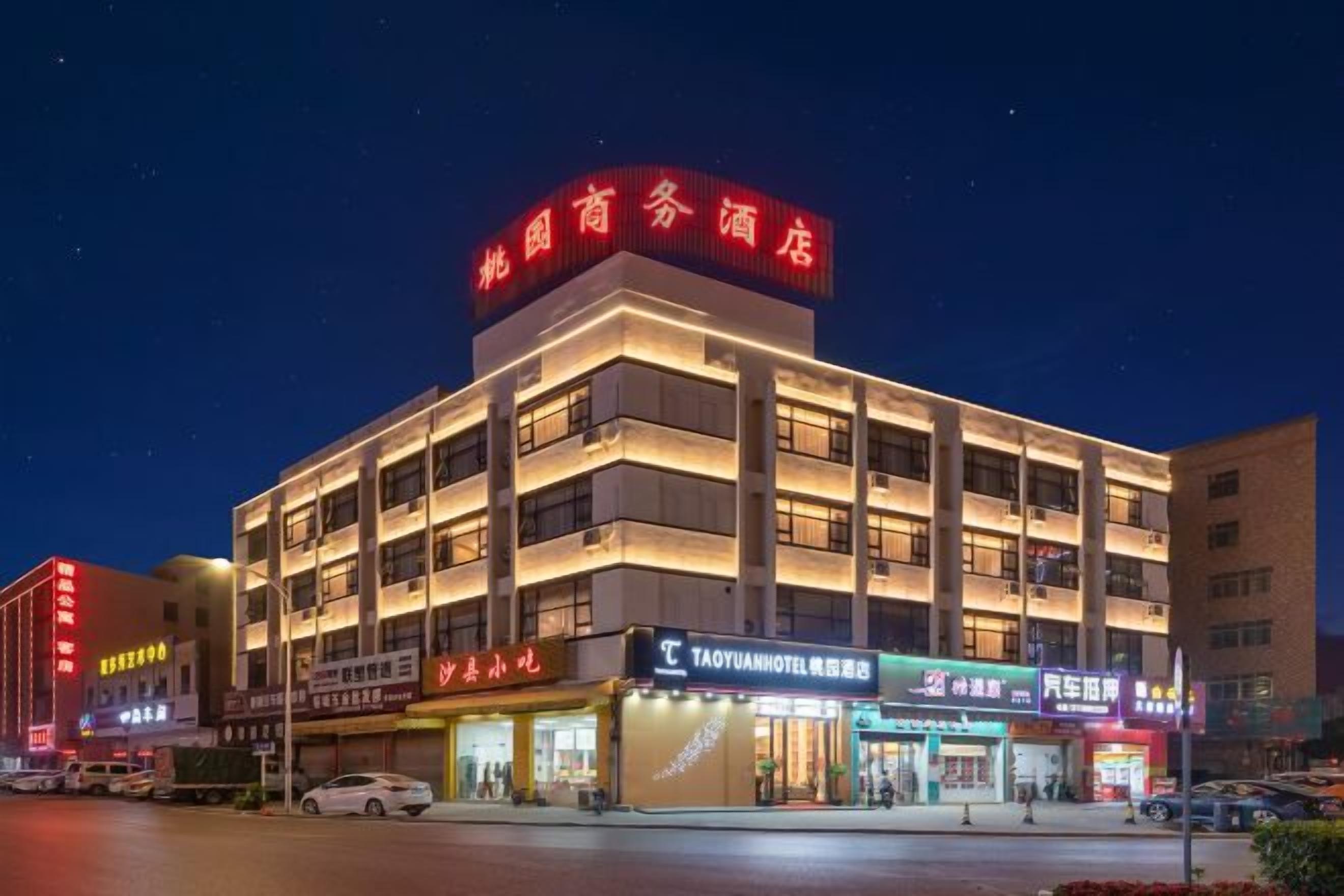 A multi-story hotel with illuminated signage, a ground-level restaurant, and a visible entrance.