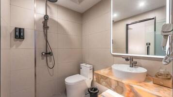 A modern bathroom with a shower, toilet, and sink.