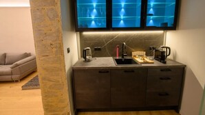 Una cocina moderna con televisión integrada, cafetera y hervidor.