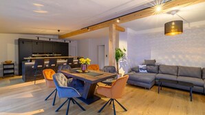 Un espace de vie moderne comprenant un coin repas, une cuisine et un coin salon.