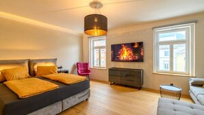 Une chambre à coucher avec un lit, une télévision, une cheminée et une fenêtre.