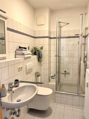 Ein Badezimmer mit Waschbecken, Toilette und einer Duschkabine.