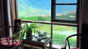 Ein Zimmer mit Blick auf eine Berglandschaft durch ein großes Fenster.