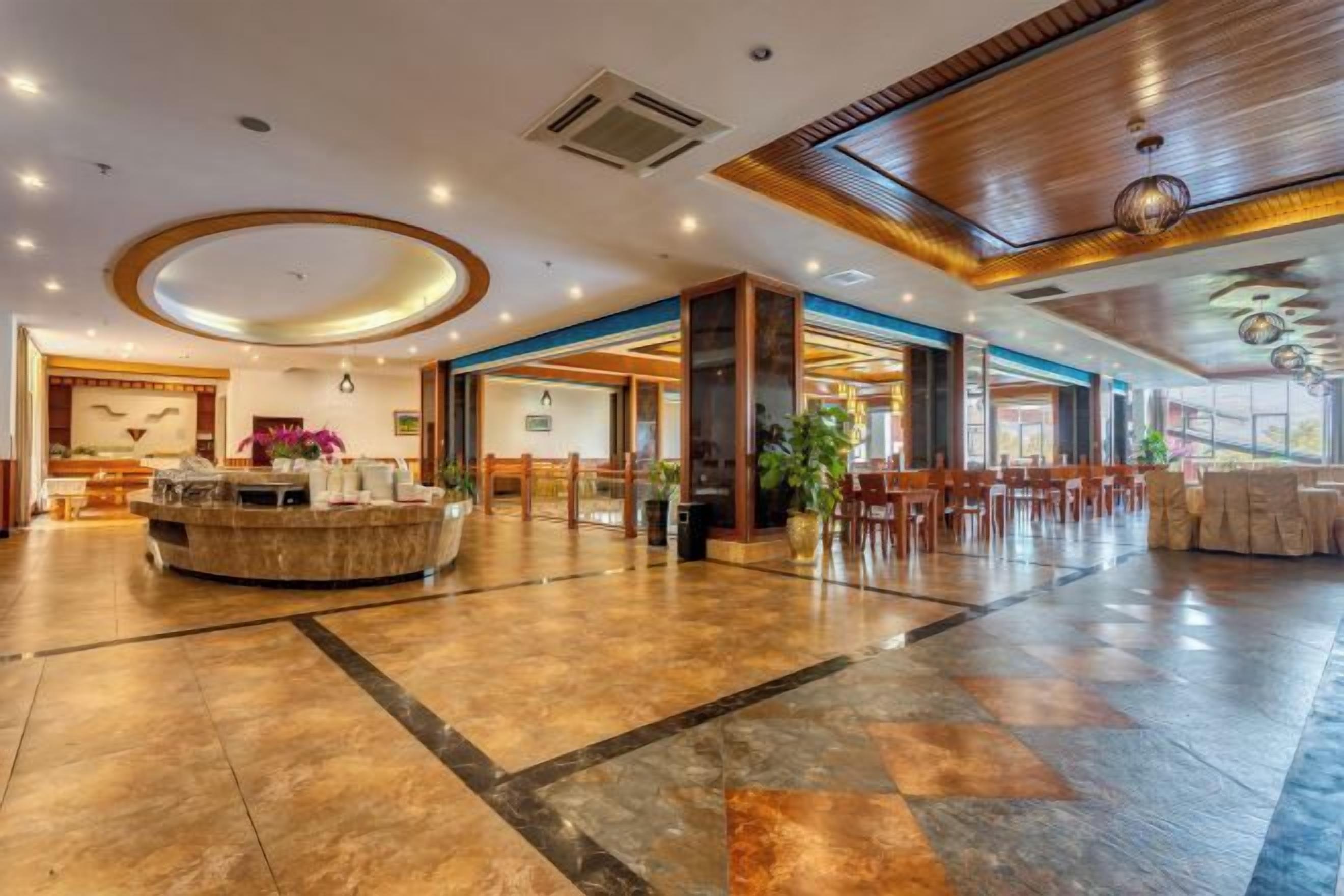 A spacious lobby with a reception desk, seating area, and a large open space with a high ceiling and modern lighting.
