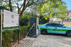 Un taxi estacionado frente a un edificio con un cartel.