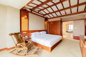 A bedroom with a wooden ceiling, a bed, a rocking chair, and a desk. - Yunti Hotel (Honghe County)
