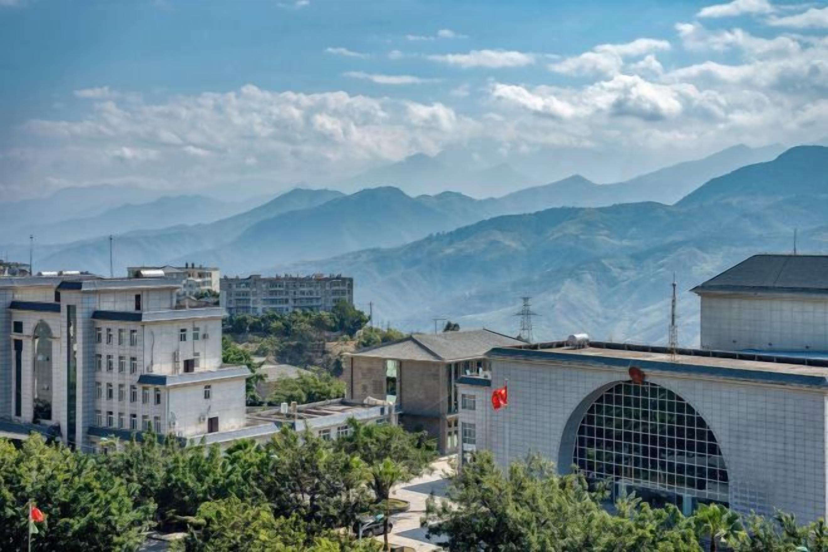 A mountainous landscape with buildings in the foreground.