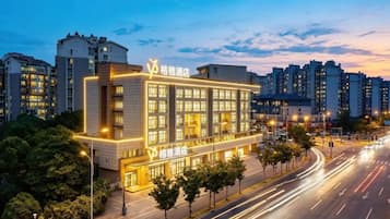 A modern hotel with a prominent entrance, multiple floors, and a well-lit facade.