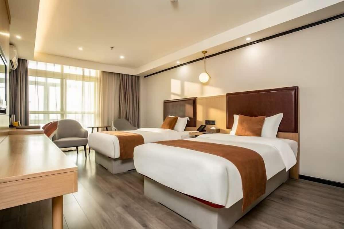 Une chambre dâhĂŽtel avec deux lits, un bureau et une chaise.