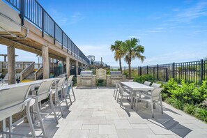 An outdoor patio with seating, a grill station, and a view of the ocean. - Beachside One 4067 | Gulf Front! 2PM Check in! Spectacular Gulf Front Unit with Gorgeous Decor only steps from the beach! (Miramar Beach)