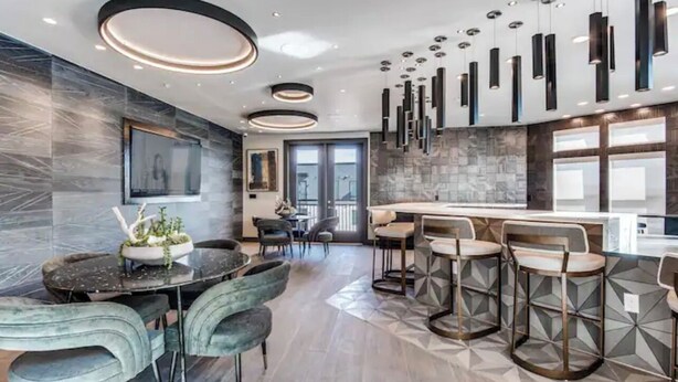 A modern kitchen with a central island, bar stools, and pendant lighting. - Cozy 2- bedroom with Smart TV’s, AC, WiFi, huge pool in amazing Area of Addison (Addison)
