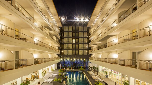A multi-story hotel with a central swimming pool, balconies on each floor, and a decorative light display at the top. - Sabai Sabana (Pattaya)