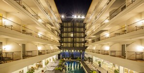 A multi-story hotel with a central swimming pool, balconies on each floor, and a decorative light display at the top. - Sabai Sabana (Pattaya)