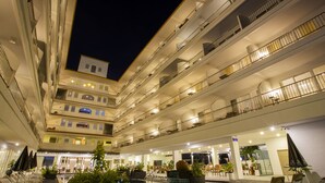 A multi-story hotel atrium with balconies, a pool area, and indoor seating. - Sabai Sabana (Pattaya)