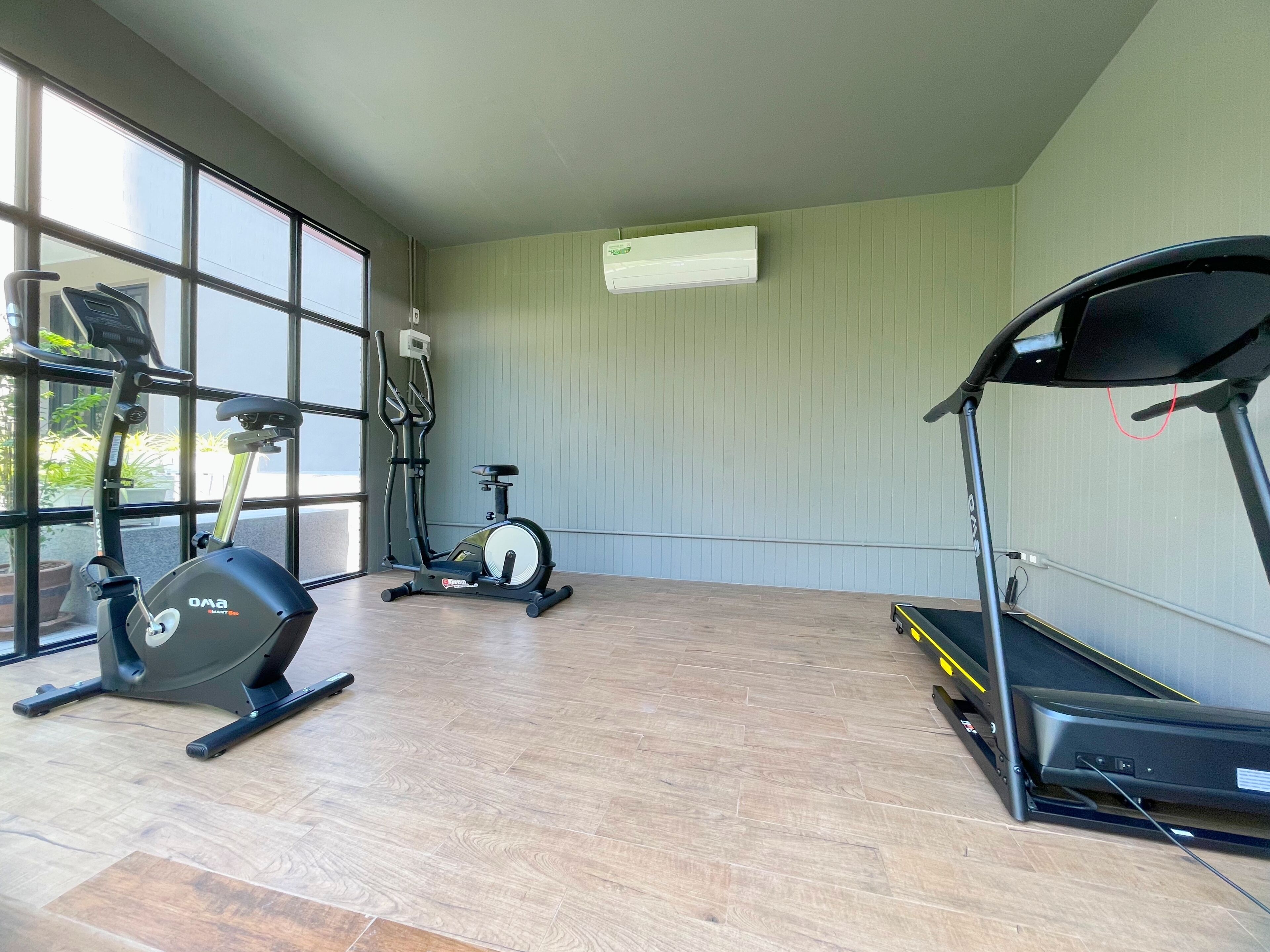 Ein Heimfitnessraum mit Laufband, Ergometer und Crosstrainer.