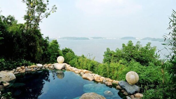 A clear view of a natural landscape with a body of water, surrounded by rocks and greenery. - Qingmu Select Hotel (Liyang Tianmu Lake Scenic Area) (Liyang)