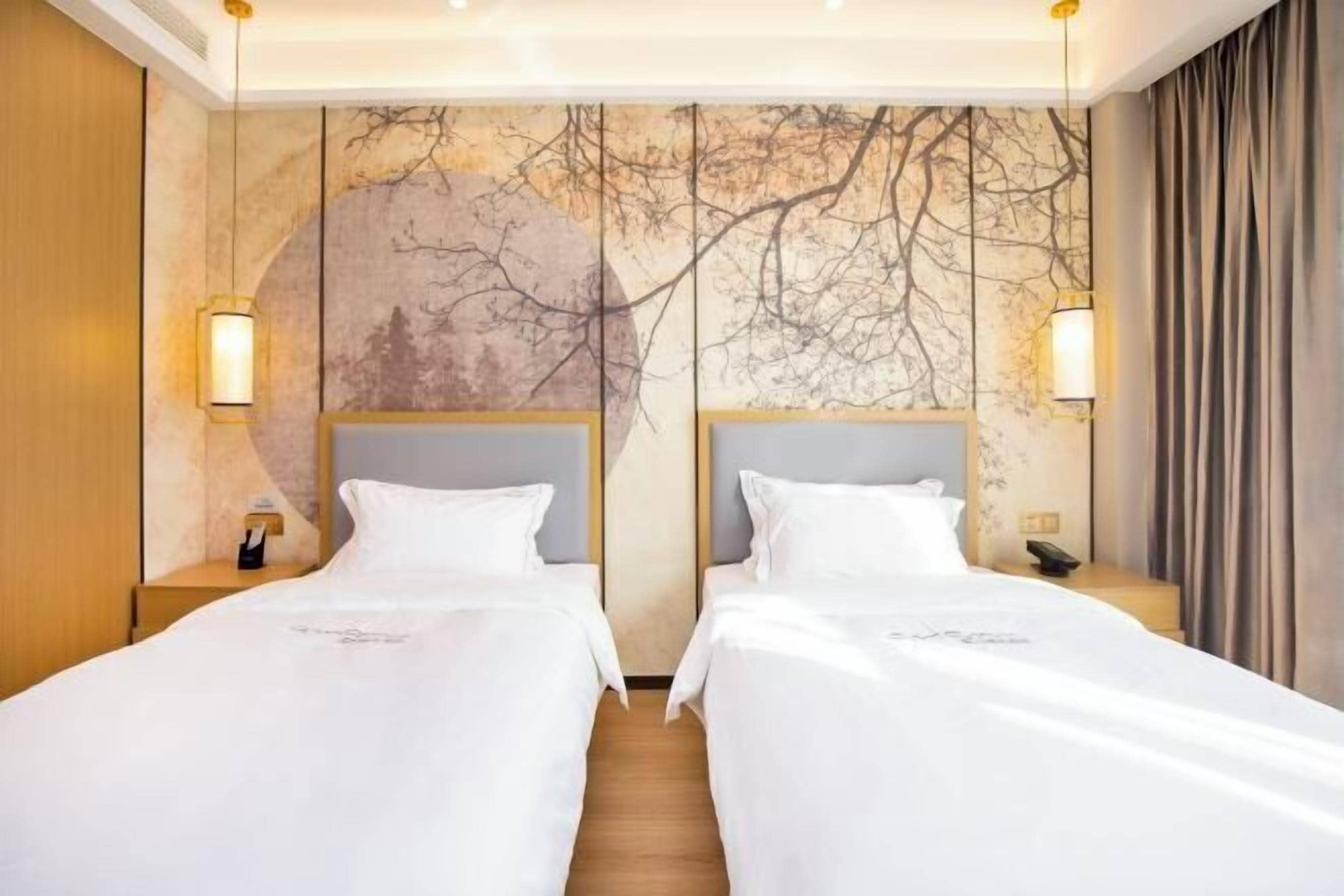 A hotel room with two beds, a large wall mural, and a wooden floor.