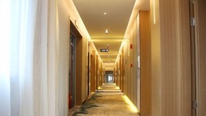 A long, narrow hotel corridor with doors on both sides, a carpeted floor, and overhead lighting. - Qingmu Select Hotel (Liyang Tianmu Lake Scenic Area) (Liyang)