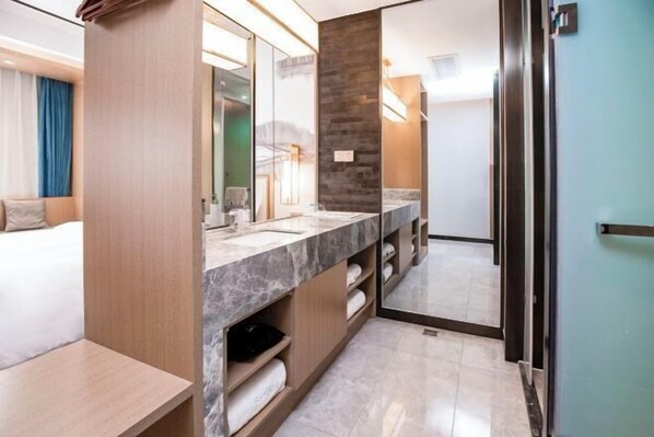 A modern bathroom with a marble countertop, a large mirror, and a wooden vanity. - Qingmu Select Hotel (Liyang Tianmu Lake Scenic Area) (Liyang)