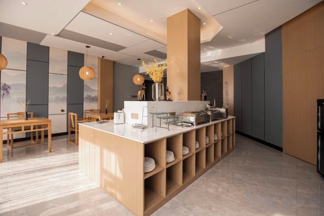 A modern interior with a central island counter, seating area, and a decorative vase.