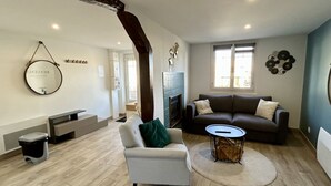A living room with a fireplace, a sofa, a coffee table, and a chair.