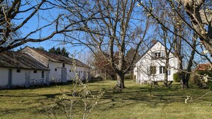 A rural setting with a white house, a tree, and a grassy area. - Anna & Jules' little house (Saint-Quentin-en-Tourmont)