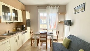 Une cuisine de taille réduite comprenant une table à manger, des chaises et un canapé.