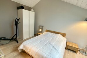 Ein Schlafzimmer mit Bett, Kleiderschrank, Schreibtisch und Stuhl.