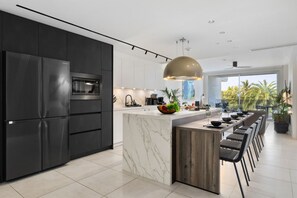 A modern kitchen with a central island, stainless steel appliances, and a large pendant light.