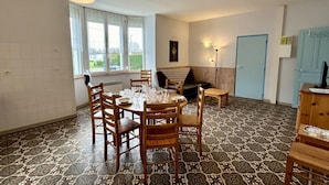 A dining area with a round table and chairs, a sofa, and a small side table.