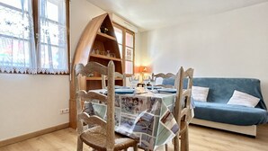 Un coin repas avec une table en bois, des chaises et un canapé bleu.