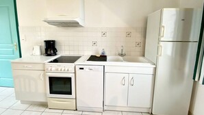 A compact kitchen with white appliances, a stove, oven, dishwasher, and a refrigerator. - Les Eglantines 3, superb apartment (Fort-Mahon-Plage)