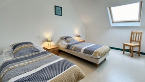 A bedroom with two single beds, a desk, a chair, a window, and a ceiling light. - Les Eglantines 3, superb apartment (Fort-Mahon-Plage)
