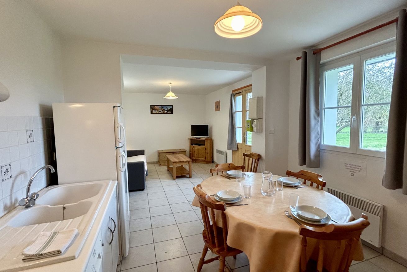 Una cocina con comedor, un lavamanos y un televisor.