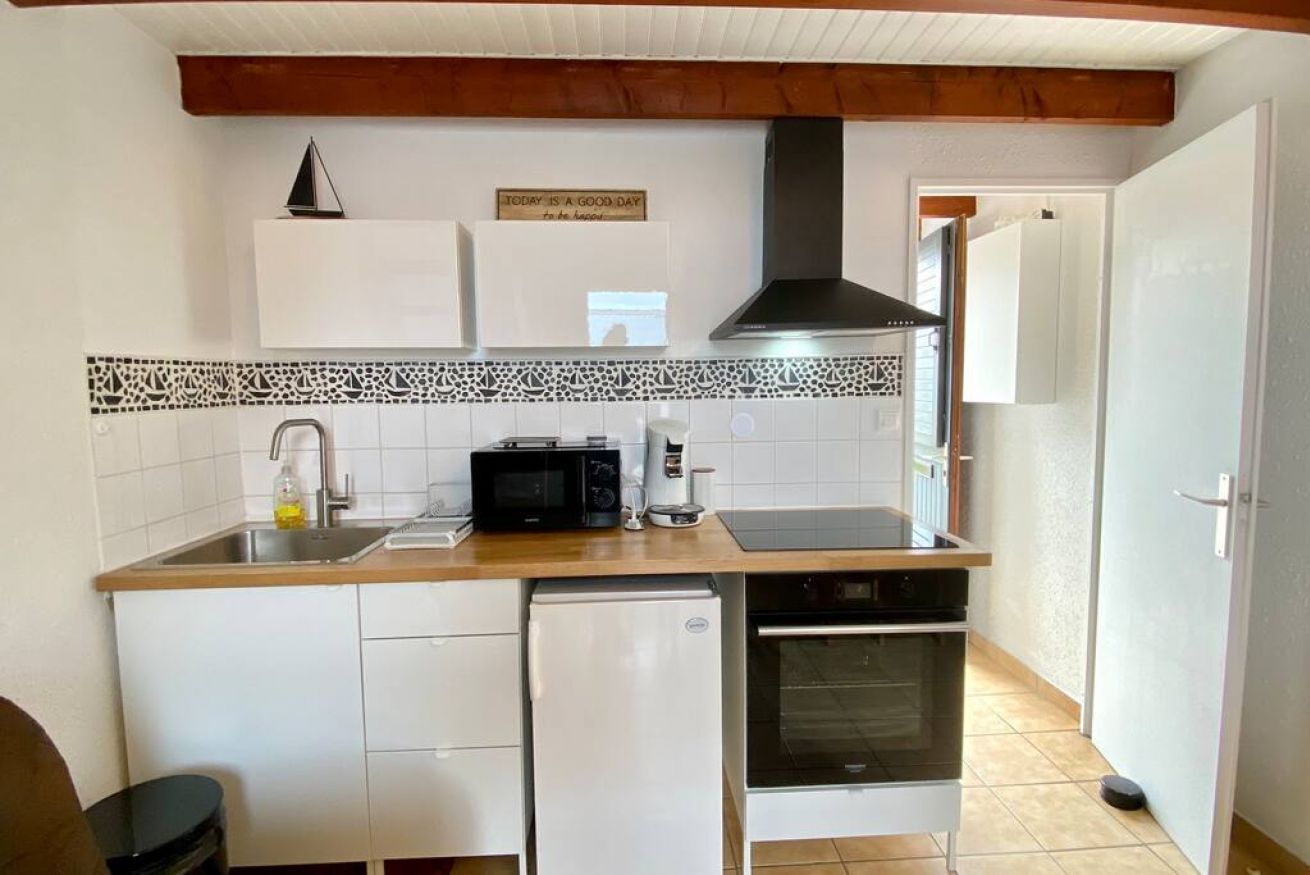 A compact kitchen with a microwave, coffee maker, and a small refrigerator.