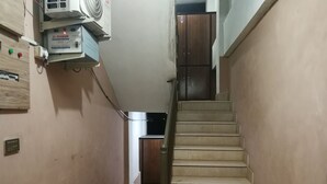 Un escalier étroit doté d’une main courante, menant à une porte située en haut.