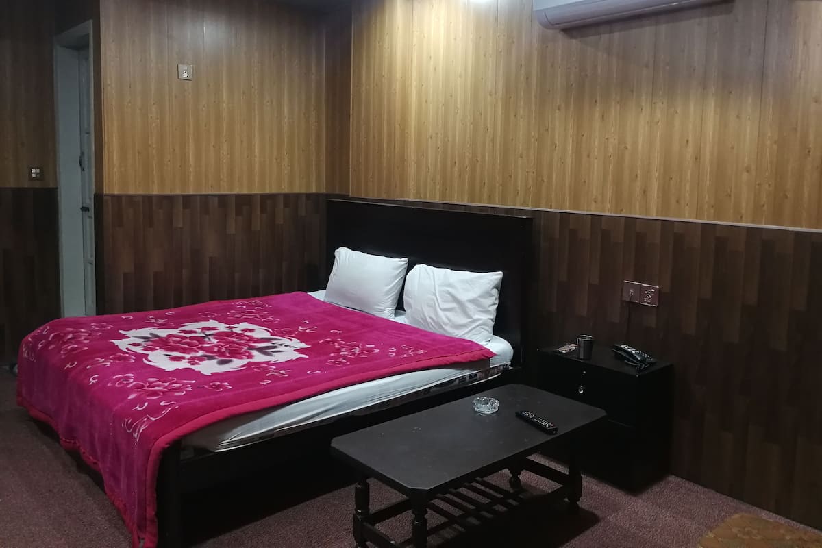 Ein Schlafzimmer mit einem Bett, einem Nachttisch und einer Klimaanlage.