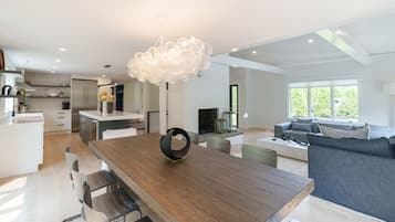 Relax in this open-plan living space with a central dining table and comfortable seating area.