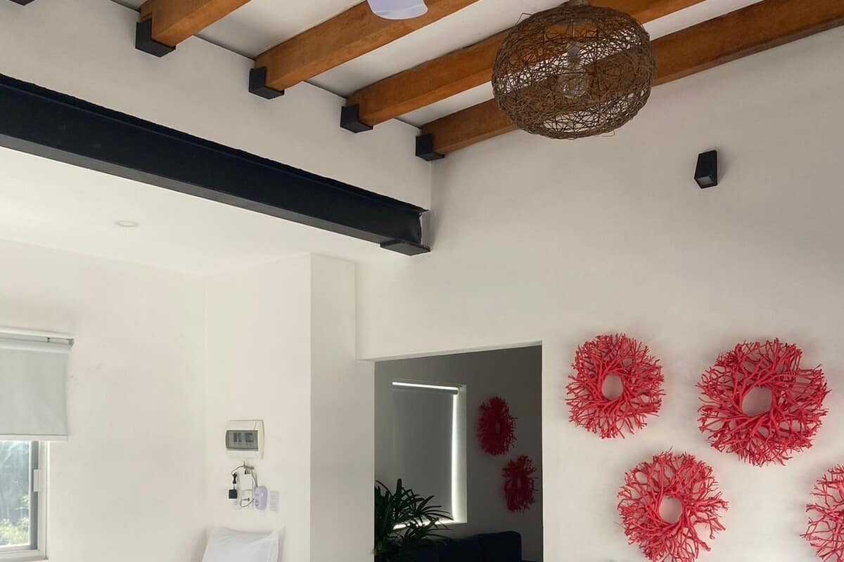 Un dormitorio con dos camas individuales, un ventilador de techo, una lámpara de fibra y un espejo.
