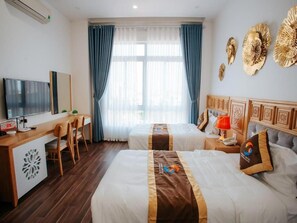 Une chambre d’hôtel avec deux lits, un bureau, une télévision et une fenêtre avec des rideaux.
