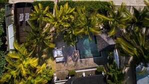 An aerial view of a beach with a pool area, palm trees, and a building with a pool. - Villa Matahari by muse villas (Black River)