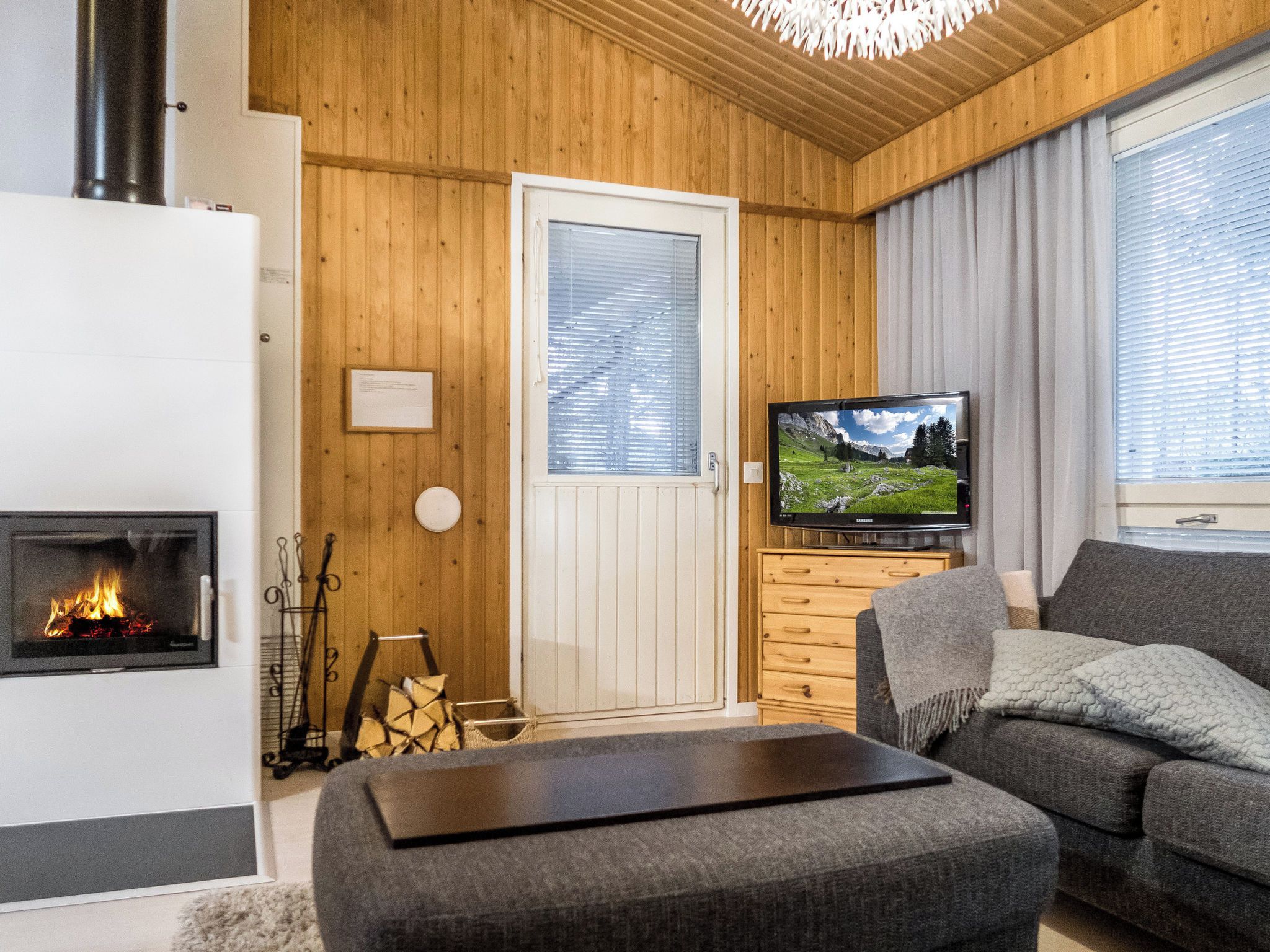 A cozy living room with a fireplace, a television, and a sofa.